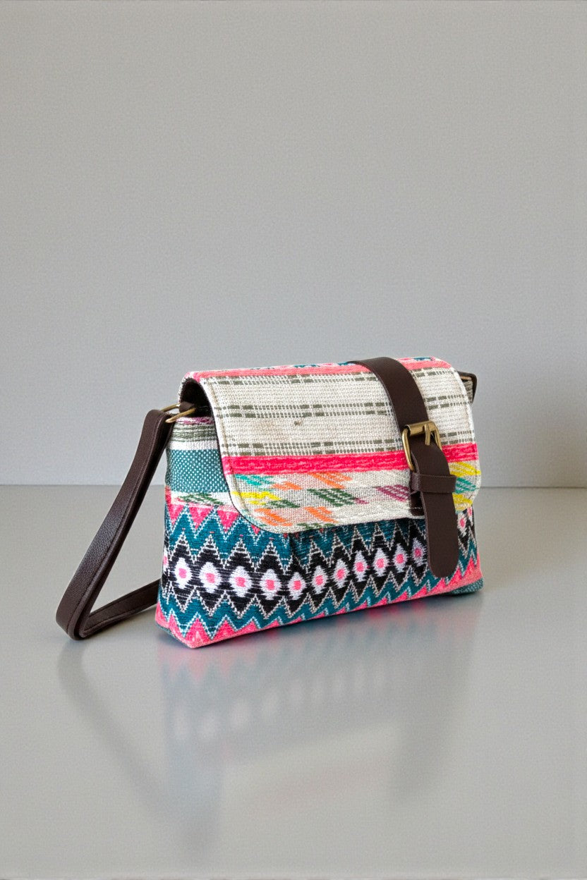 Colorful patterned Bahnaz handbag with brown strap on a gray surface